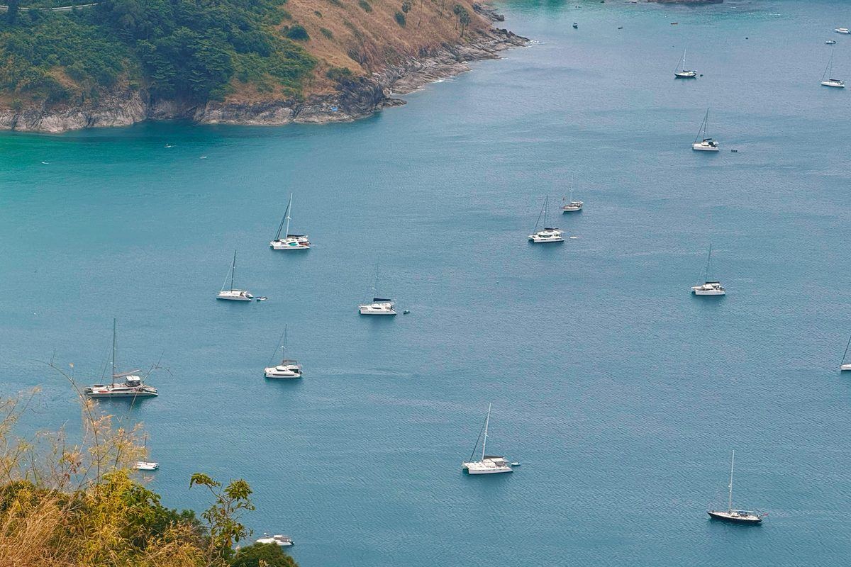 Sailing yachts and catamarans at anchor in a bay off Phuket