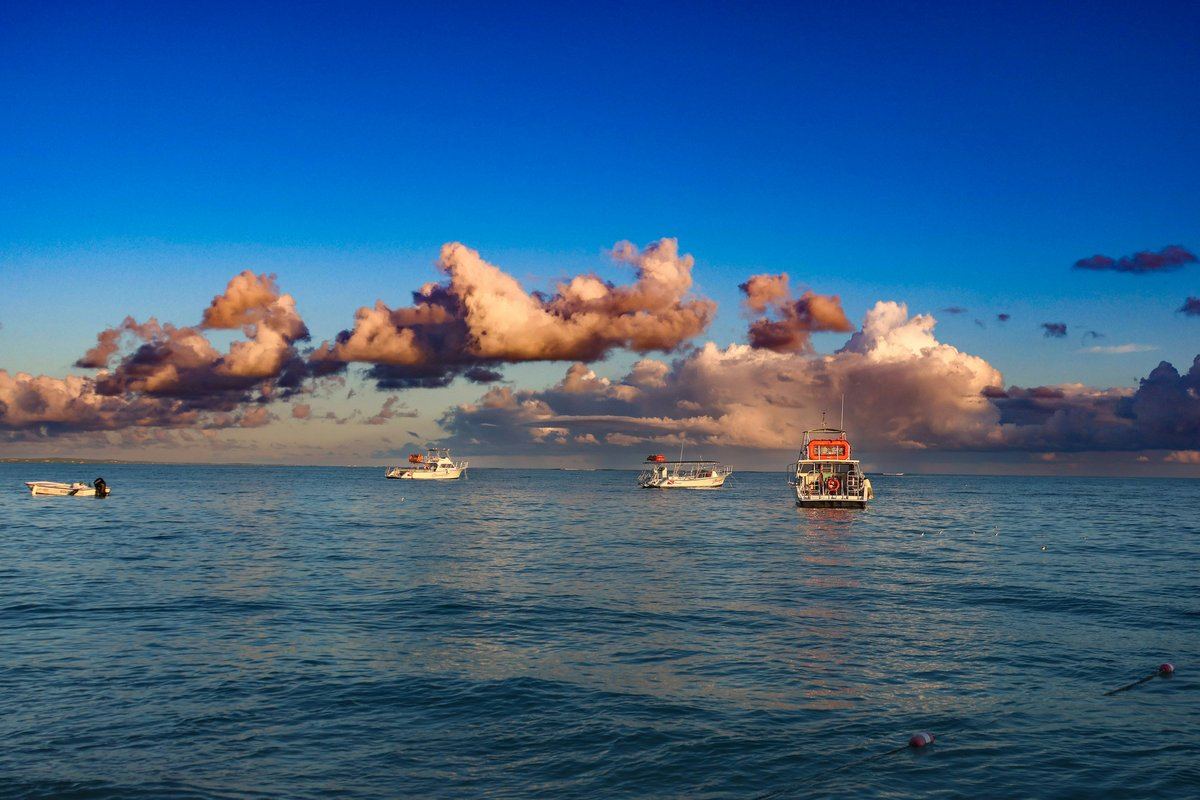Boats at anchor off The Bight, Providenciales, under sunrise clouds